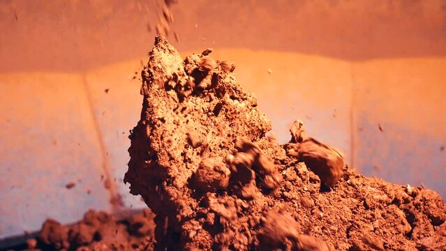 Static shot of small clay stones forming a large pile. Slow motion 25perc. 4k.