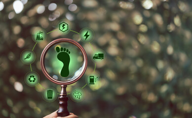 Carbon footprint with magnifying glass on green background. Carbon Footprint is total amount of...