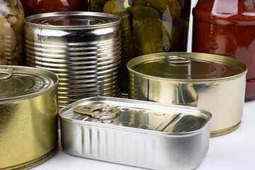 Jars of pickles, canned meat and fish  on a white background.