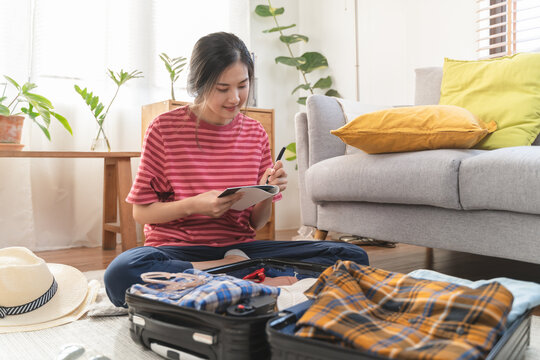 people check clothes into luggage in suitcase checklist before holidays trip