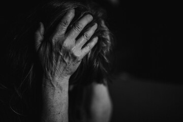 Close up of depressed senior woman holding her head.