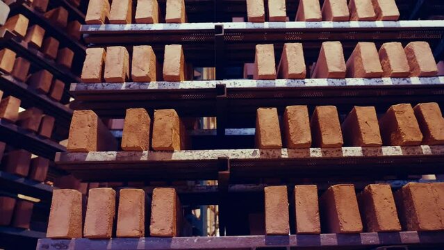 Rotating shelves of red oldschool bricks. Dried bricks from the kiln, before laying and firing. Brick production factory. 4k.
