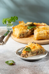 Greek pie spanakopita on gray background. Spanakopita spinach pie  from filo pastry with feta cheese and chard leaves.