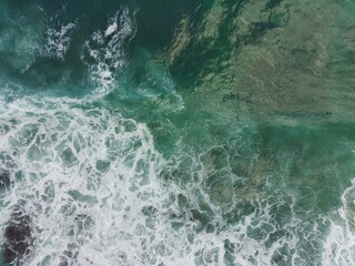 Fototapeta na wymiar blue and green waves crashing against the reef making a beautiful natural pattern.