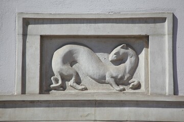 Ermine bas-relief figure on the wall of a historical building in Warsaw, Poland