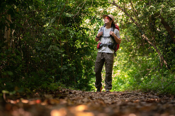 happy asian student backpack travel in trail hike trekking journey extreme sport activity trip in nature forest environment mountain in summer at sunset time
