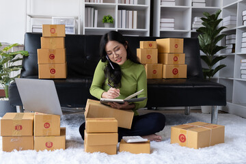 Small business SME concept. Young happy business owner working and talking with her phone with customer.