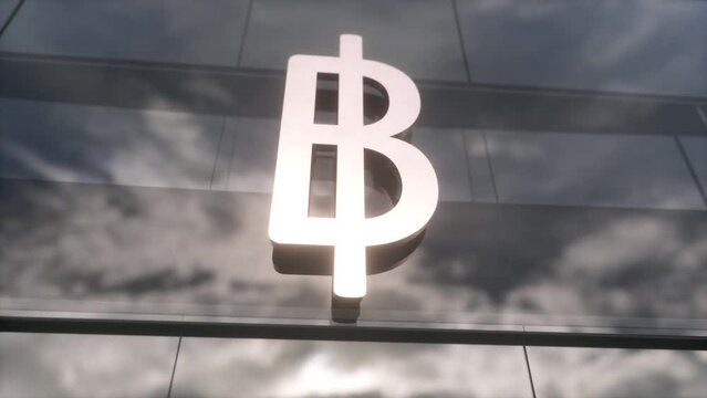 Thai baht currency sign on a modern glass skyscraper. Business and finance concept