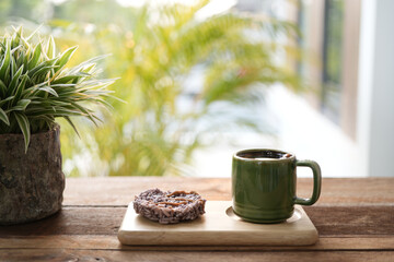 Green cup and Rice crackers with plant on blue wooden table