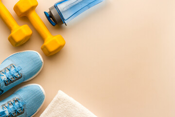 Sport background with sneakers and dumbbells, top view