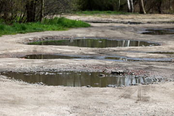 Kałuże wody po deszczu na drodze i chodniku