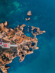 Fototapeta premium An aerial top down view of Ponte da piedade in Lagos, Algarve, Portugal. Showing the lighthouse and the atlantic ocean. 