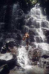 Obraz premium Couple stand under a large waterfall