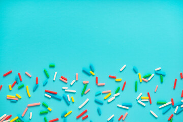 flat lay of colorful sprinkles over blue background, decoration for banner, poster, flyer, card, postcard, cover, brochure, designers, copy space