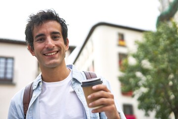 Young man kicks off his busy day with a refreshing takeout coffee on his way to work in the city.