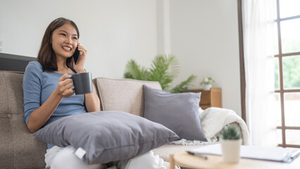 Happy young asian woman using mobile phone  talking with friends on cell phone