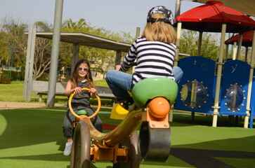Girl 5 years old and boy 4 years old, cheerful friends. Concept: older sister, first love. Children play in the park. The girl takes care of her younger brother.