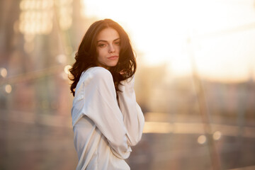 Young girl in white shirt standing in rays of setting sun