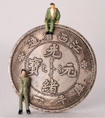 Chinese coin with 2 miniature human figures