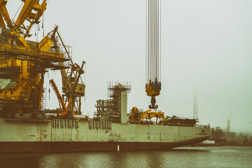 Statek dźwig do montażu instalacji wiatrowych na morzu w mglisty dzień.