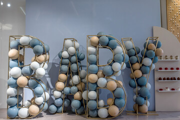 big letters BABY from balloons of different colors on a children's photo zone for photographing a children's holiday. Children's modern photo zone for the holiday. 