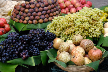 Pune Fruit market, Street fruit vendor selling some apples, Fig, ramphal, grapes, Black grapes.