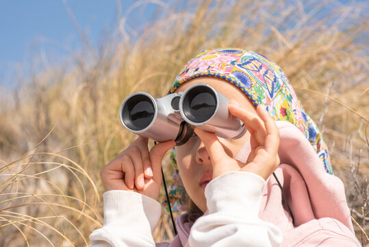 The girl on the mountain, looking through binoculars. High quality photo