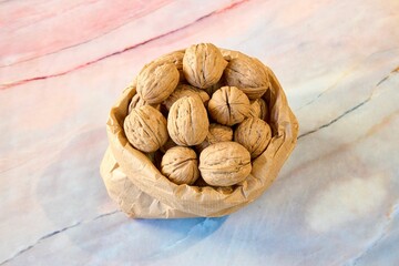 Top view closeup of a paper bag full of walnuts on the kitchen table