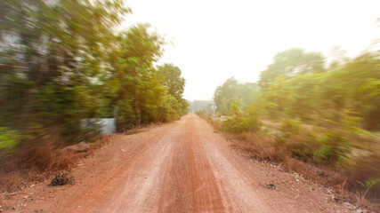 A dirt road in a rural area far from the city.
