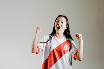 Photograph of Peruvian fan woman celebrating a goal of her team. Concept of people, emotions and...