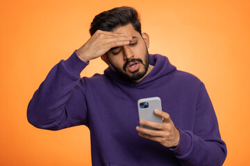 Indian man use mobile cell phone typing browsing, loses becoming surprised sudden lottery results,...