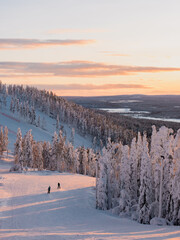 Winter sunrise view of ski slopes, skiers and mountains in Levi, Kittilä, Lapland, Finland