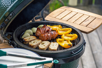 outdoor grilling - ready to eat grilled sausages, yellow paprika, onions and bread from the charcoal grill