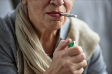 Closeup of adult woman lighting up cigarette smoking for therapeutic purpose and medical treatment - obrazy, fototapety, plakaty