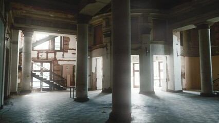 Large hall of old abandoned ruined cinema or ancient mansion with columns and stairs.