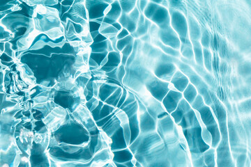 Waves on light blue water. Cosmetic textured background. Splashes and bubbles, sun glare. Selective focus, defocus
