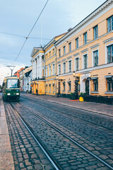 Fototapeta na wymiar Look of tram train passing by aligned wiht buildings over sunset in helsinki 