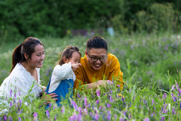 happy asian family with little girl enjoy the day  in the spring field