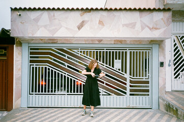 Woman in black dress looking for something and closing her handbag