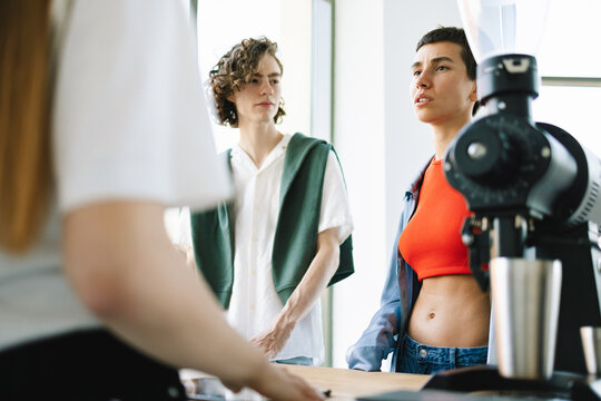 Two Casually Dressed Zoomers are Discussing Choices in Restaurant