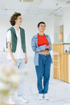 Young Couple Standing in White Reception Hall With Happy Relaxed Faces