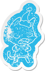 talking cat cartoon distressed sticker of a wearing santa hat