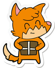 sticker of a cartoon friendly fox with gift