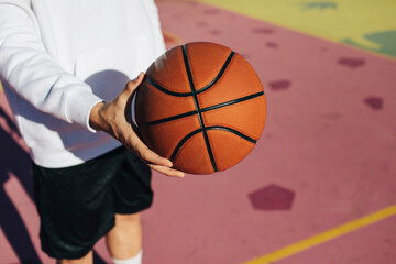Detail of a basketball ball on a colorful court