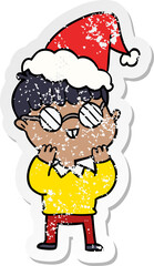 distressed sticker cartoon of a boy wearing spectacles wearing santa hat