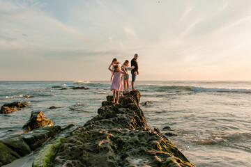 Family with two tween daughters spending evening at beach 