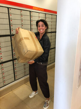UGC happy woman with box at post office