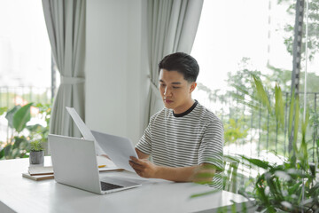 Young student analyze some statistical data and learning at home