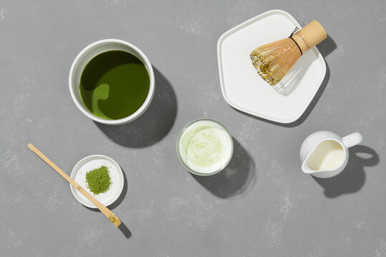 Matcha tea in a white cup with bamboo whisk and spoon