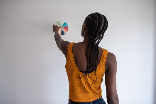 Anonymous black designer selecting wall paint color